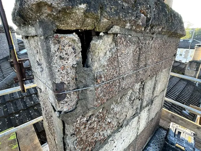 Chimney stack with cracked and spalling masonry before repair